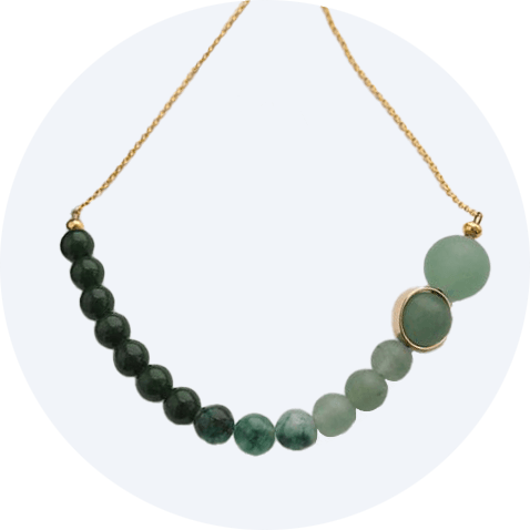 A necklace made up of labradorite, aventurine and amazonite beads in varying shade of green on a brass chain