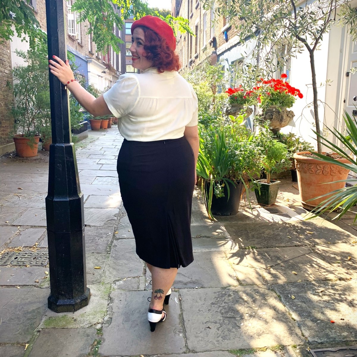 Back view of vintage style black pencil skirt with 1940s style blouse worn tucked in