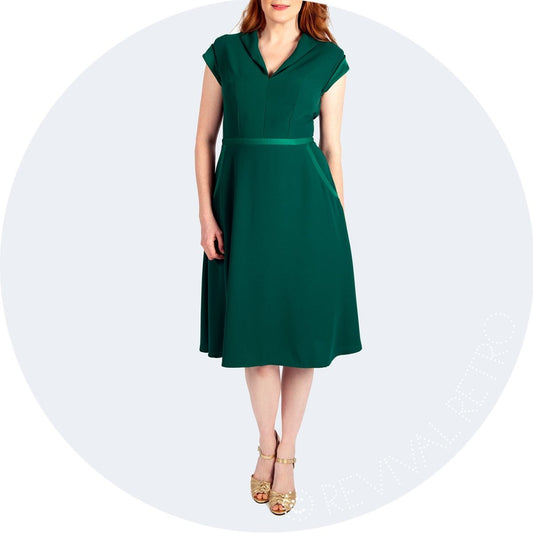1950s Style Green Satin and Crepe Dress. A v-cut neckline, capped sleeve and an A line knee length skirt make this dress a winner for lots of different body shapes.  Nipping in at the waist it accentuates the narrowest point, giving a womanly, hourglass silhouette.  With the added contrast detailing on the  waistband, pockets and sleeves the Cambridge dress is a unique offering from our own range.