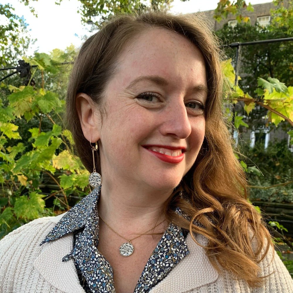 William Morris inspired necklace as worn by Mary who wears the matching earrings and smiles at the camera. Her vintage style cardigan and floral 1940s blouse is just showing.