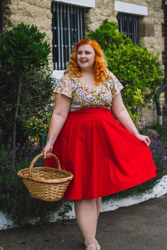 Model wearing floral Charleston blouse with red Nottinghill skirt