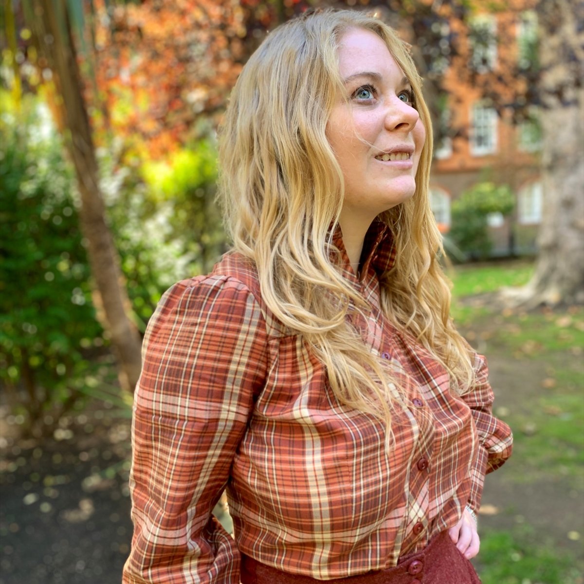 Vintage inspired blouse with long sleeves and round collar- The Bishopess Blouse by Emmy Design Sweden in rust plaid as worn by Carlisle who has long blonde hair and blue eyes